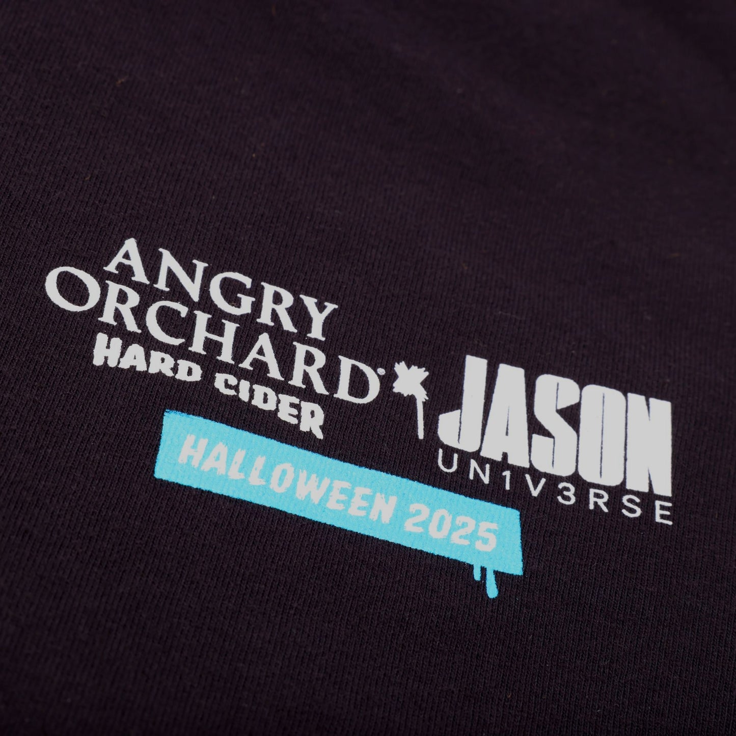Close up of the front screen print that features text of Angry Orchard x Jason Universe Halloween 2025.