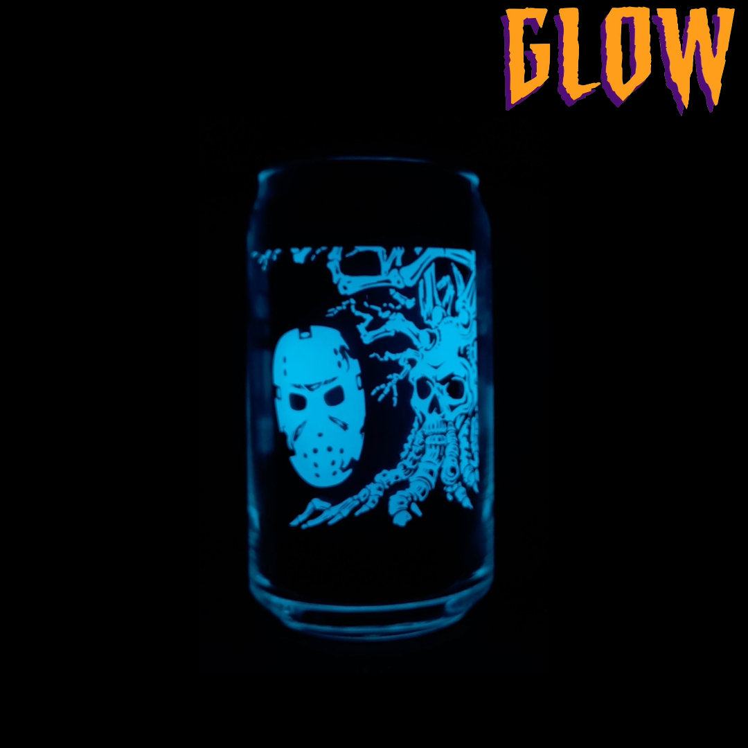 Angry Orchard hard cider can glass with Halloween-themed design featuring Jason mask and skeletal tree. Word GLOW to describe one glass's glow in the dark feature.