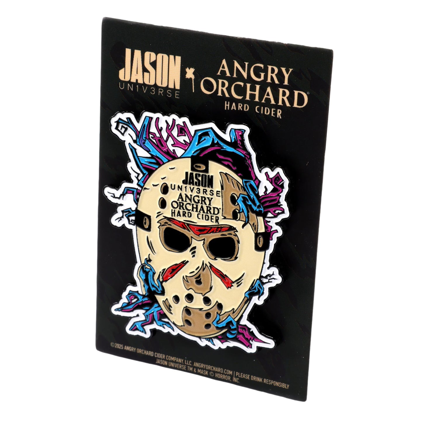 Enamel pin features Jason Universe mask on a black background with purple and blue branches enwrapping the mask, there is writing "JASON Un1v3rse x Angry Orchard Hard Cider".