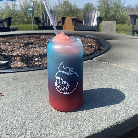 A frosted 16oz can-shaped glass with a pink-to-mint ombre gradient. One side shows the Angry Orchard logo with "Walden, New York" text; the other side features the brand's signature bitten apple icon. In a third image, the glass is filled with a frozen drink, revealing a bright red-to-blue ombre color change.